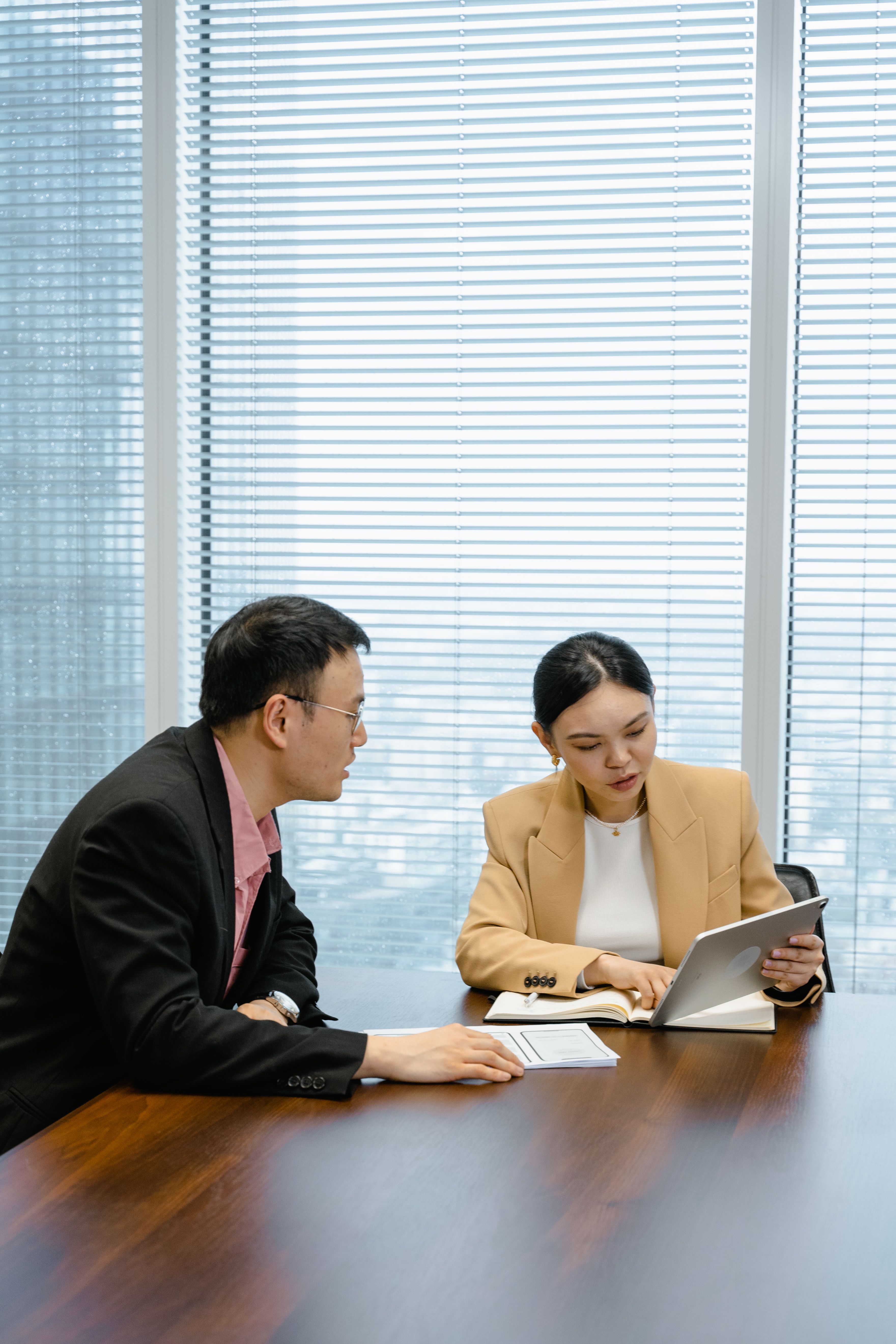 Two professionals reviewing work on a laptop in a modern office